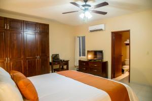- une chambre avec un lit et un ventilateur de plafond dans l'établissement Bugambilias Suites, à Loreto