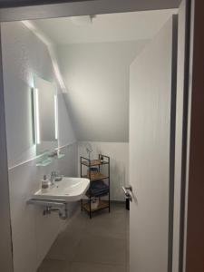 a white bathroom with a sink and a mirror at Waldhotel Süllhof in Steyerberg