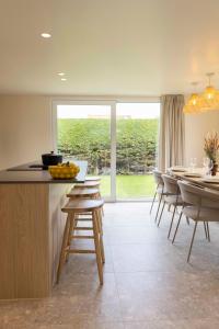 eine Küche mit einer Theke mit Hockern und einem Tisch in der Unterkunft ElloStays in Middelkerke