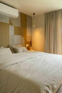 ein großes weißes Bett in einem Schlafzimmer mit Fenster in der Unterkunft ElloStays in Middelkerke