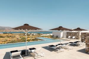 a view of a pool with chairs and umbrellas at TWWO Antiparos in Antiparos