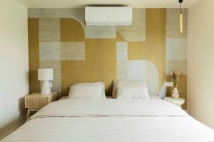 a bedroom with a large bed with white sheets at ElloStays in Middelkerke