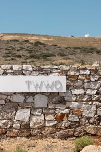 a stone wall with a sign on top of it at TWWO Antiparos in Antiparos
