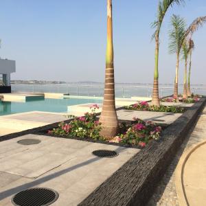 un complejo con palmeras y piscina en Torre Bellini, en Guayaquil