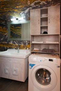 a bathroom with a washing machine and a sink at Green Bay Studio 1 in Sifnos