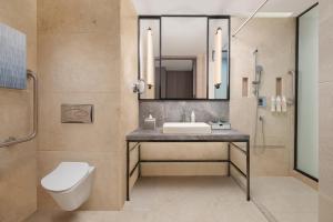 艾哈迈达巴德Le Meridien Ahmedabad的带水槽、马桶和镜子的浴室