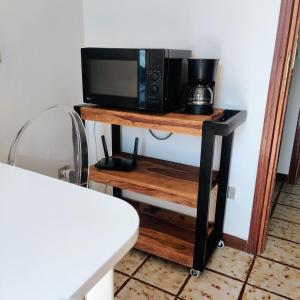 a microwave on a wooden shelf with a tv on it at Peaceful Lakefront in Marone