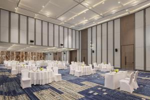 艾哈迈达巴德Le Meridien Ahmedabad的摆着白色桌子和椅子的宴会厅