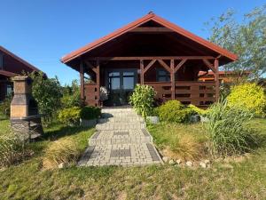 a house with a pathway in front of it at Domki Nad Stawem Mazury D4 in Mrągowo