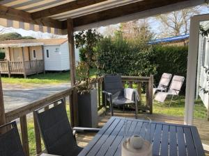 a patio with chairs and a table on a deck at Mobil homme 10 in Arvert
