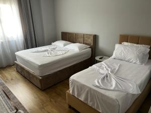 two twin beds in a room with a window at Denis room in Tirana