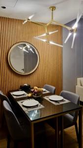 a dining room table with chairs and a mirror at Cosy 2 bedroom family apartment Layan beach in Layan Beach