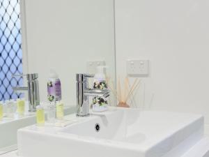 un bagno con un lavandino bianco e uno specchio di Park Ridge Retreat 4BR 2Bath with Outdoor a Park Ridge Altre 17 foto