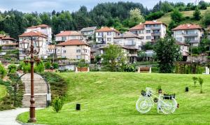 a bike parked in the grass in front of a city at Къща за гости "При Примо" in Zlatograd +11 photos