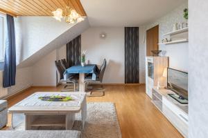 a living room with a table and a tv at Haus Seeblick _ Wohnung 1 in Dagebüll