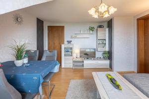 a living room with a blue table and a kitchen at Haus Seeblick _ Wohnung 1 in Dagebüll