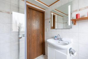 a bathroom with a sink and a toilet and a mirror at Haus Seeblick _ Wohnung 1 in Dagebüll +24 photos