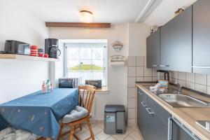 cocina con mesa y fregadero en Haus Seeblick _ Wohnung 2, en Dagebüll