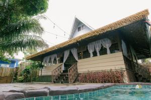 a house with a swimming pool in front of it at Balay sa Gugma in Tagaytay