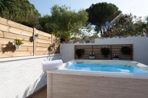 a jacuzzi tub in a backyard with a fence at AHR Residence Porto Pollo in Porto Pollo