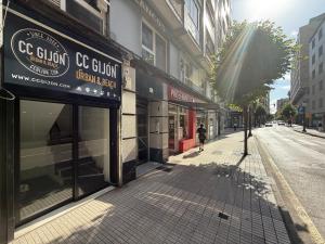 a person walking down a street in front of a store at CC Gijon in Gijón