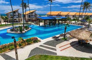 a swimming pool at a resort with palm trees at Taiba Beach Resort 03 Apto 2 quartos in São Gonçalo do Amarante