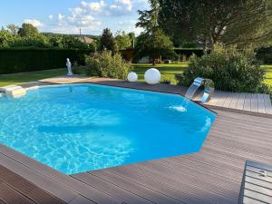 a large blue swimming pool on a wooden deck at Dépendance de 45m2 à louer in Saint-Vite