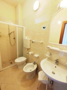 a bathroom with a toilet and a sink and a mirror at Hotel Milord in Cesenatico +84 photos