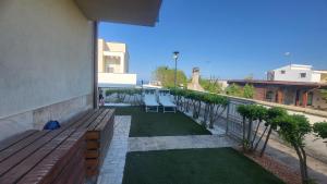 a balcony with a wooden bench and grass at Apartment Gaia in Nardò