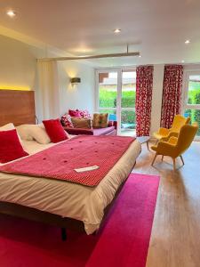 a bedroom with a large bed with a red blanket at Hotel Les Vallées Labellemontagne in La Bresse