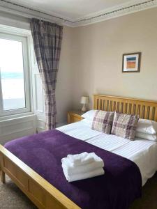 Un dormitorio con una cama con dos toallas encima. en McCaig's Tower Apartment, en Oban