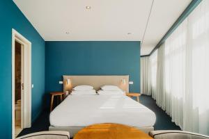 a bedroom with a bed with blue walls and chairs at Velamar Boutique Hotel - Adults Friendly in Albufeira