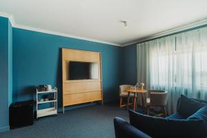 a living room with a couch and a tv at Velamar Boutique Hotel - Adults Friendly in Albufeira