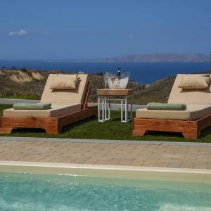 two beds and a table next to a swimming pool at Oliva Emerald Eco - Secluded Off-Grid Vineyard Villa in Káto Váthia