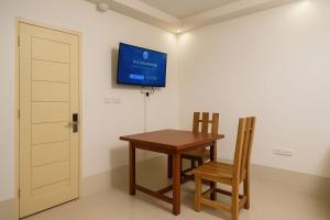 a table and two chairs and a television on a wall at Iwa Hotel in Tagbilaran City