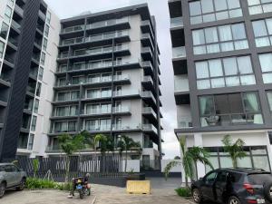 a man on a motorcycle in front of two tall buildings at Nova luxe 2 Bed Executive Stay in Accra