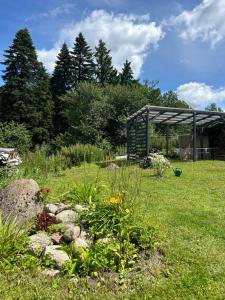 a garden with a shed in the middle of a field at Bocianie Gniazdo in Chwalimki