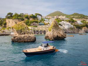 una barca in acqua con una città sullo sfondo di Blue Dream Suites a Salerno