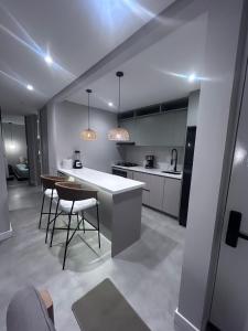 a kitchen with a counter and some chairs in it at Puesta de Sol! Apartamento in Villavicencio +8 photos