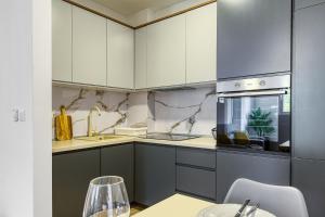 a kitchen with gray and white cabinets and a sink at Sunny Side Wellness Resort & Spa in Budva +28 photos