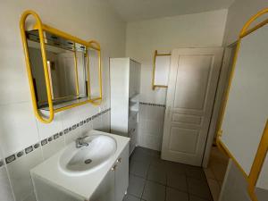 a white bathroom with a sink and a mirror at House near Tarnos metro beach in Labenne