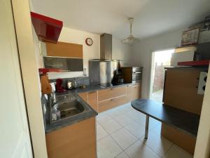 a kitchen with a sink and a table in it at House near Tarnos metro beach in Labenne