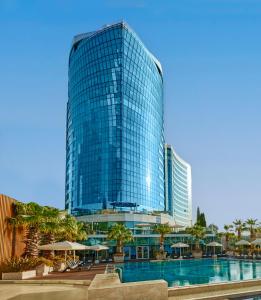 a tall glass building with a pool in front of it at Hyatt Regency Istanbul Atakoy in Istanbul