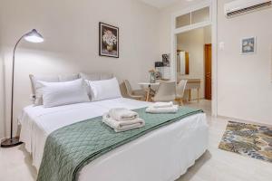 une chambre avec un lit blanc avec des serviettes dessus dans l'établissement Gabriel's cozy central house in Corfu town, à Corfu