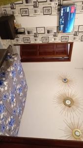a room with a desk with a tv and a couch at Onalo HLM in Dakar