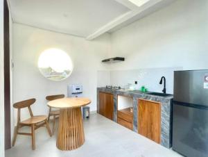 坎古Mahayasa Villa with garden的配有木桌和冰箱的厨房