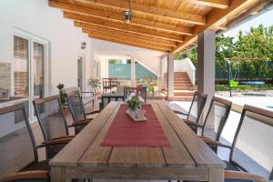 une table et des chaises en bois sur une terrasse dans l'établissement Villa Marija Ana by Istrialux, à Melnica