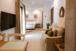 ein Wohnzimmer mit Sofa und Fernseher in der Unterkunft Apartamentos JR Alborada in Tarifa