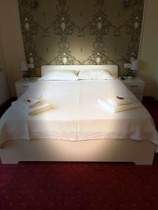 a bedroom with a white bed with two towels on it at Eden Villa in Ocina de Jos +79 photos