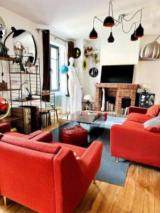 ein Wohnzimmer mit roten Möbeln und einem Kamin in der Unterkunft Maison Poppins Cergy Island of Leisure Cergy Port in Cergy